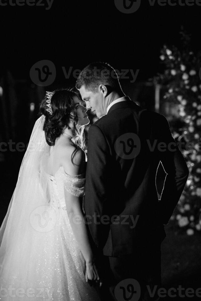 girl and guy against the background of a night wedding arch photo