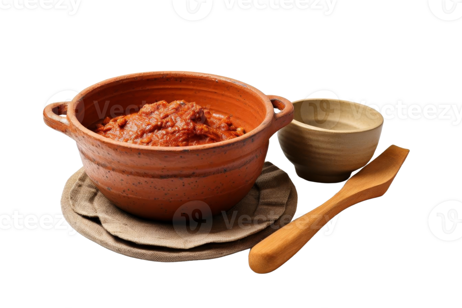 A bowl of red sauce sits on a plate with a spoon next to it. The bowl is made of clay and the spoon is wooden. Concept of comfort and warmth, as the red sauce png