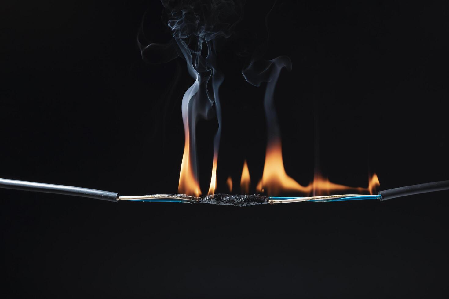Flames from electric shocks Short-circuited cables cause sparks, explosions, excessive power usage, damaged and non-standard equipment. on a dark black background photo