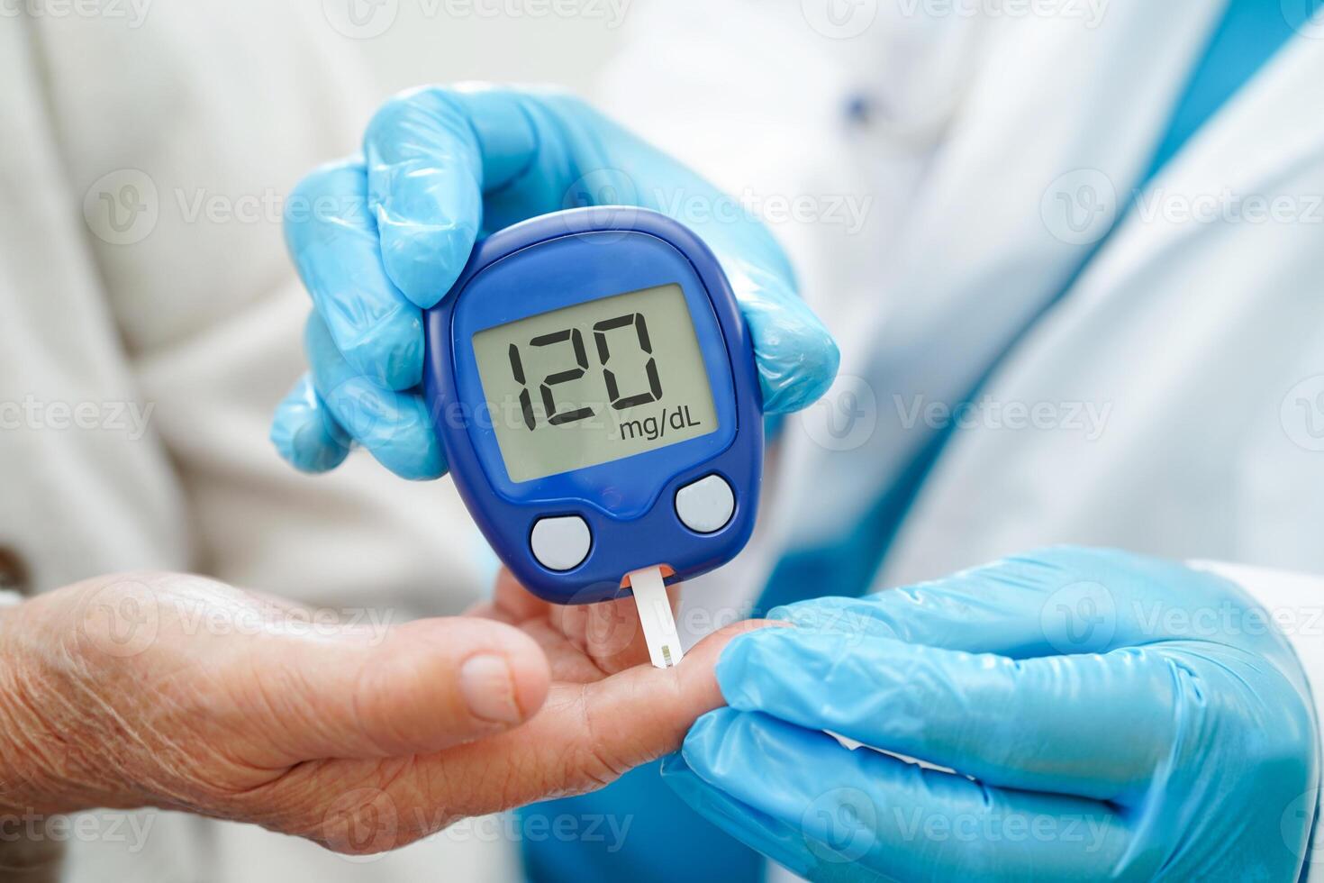 Asian doctor using digital glucose meter for check sample blood sugar level to treatment diabetes. photo