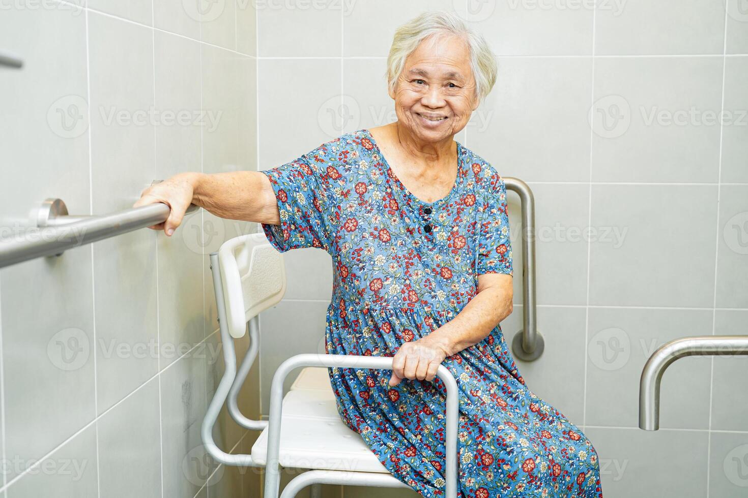 Asian elderly old woman patient use toilet support rail in bathroom, handrail safety grab bar, security in nursing hospital. photo