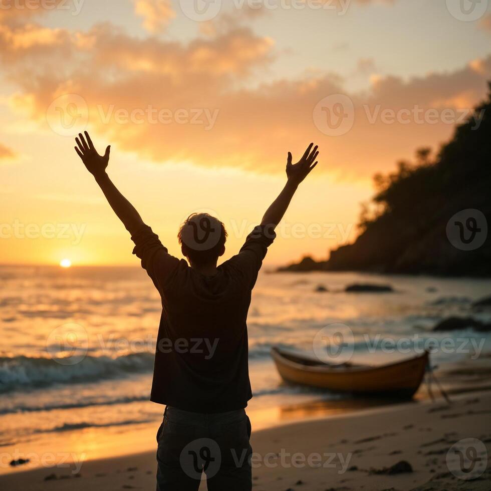 A man is standing on the beach with his arms raised photo