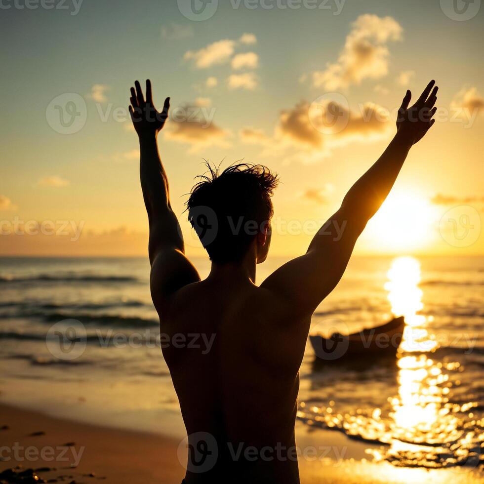 A man is standing on the beach with his arms raised photo