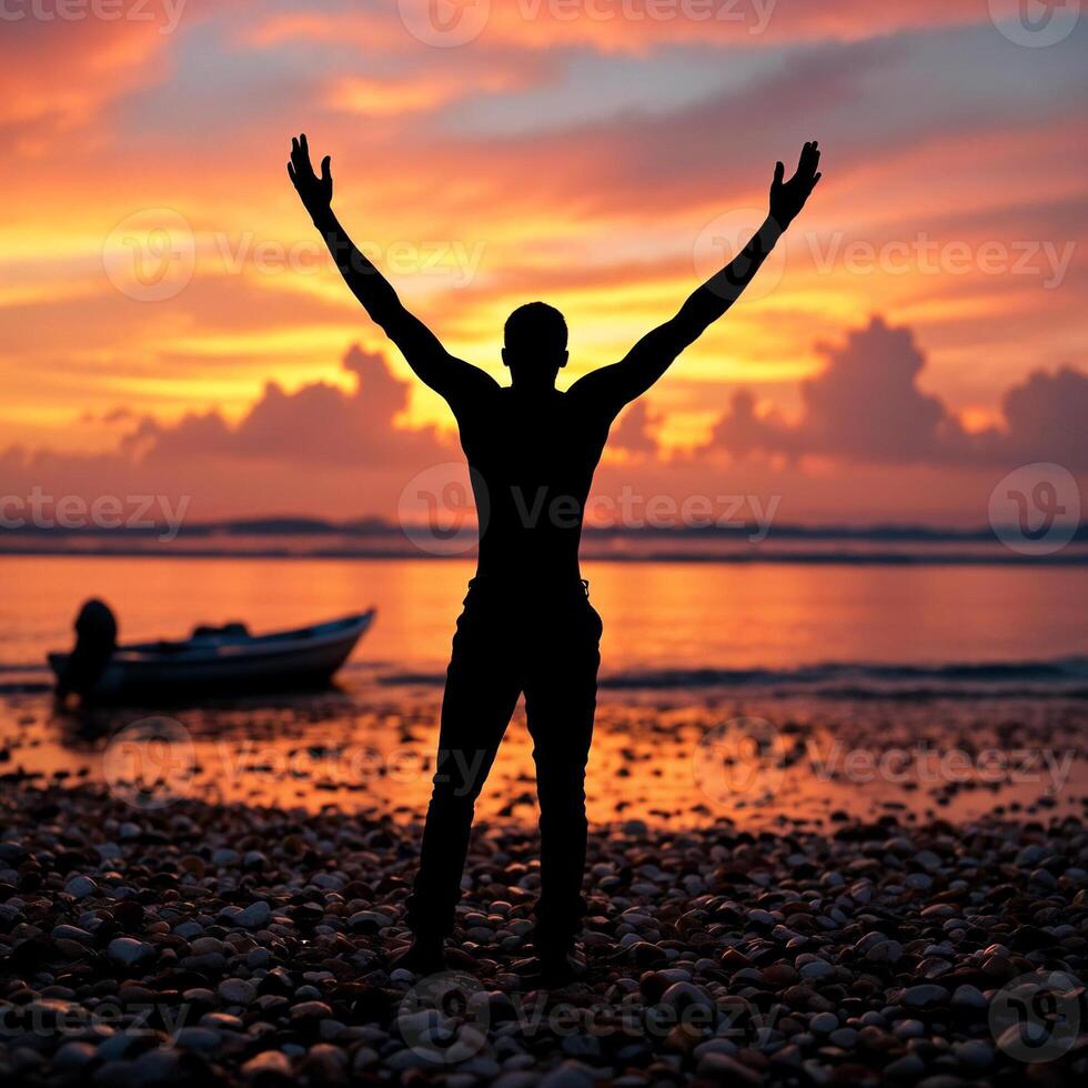 A man is standing on a beach with his arms raised photo