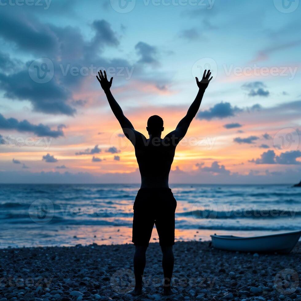 A man is standing on a beach with his arms raised in the air photo