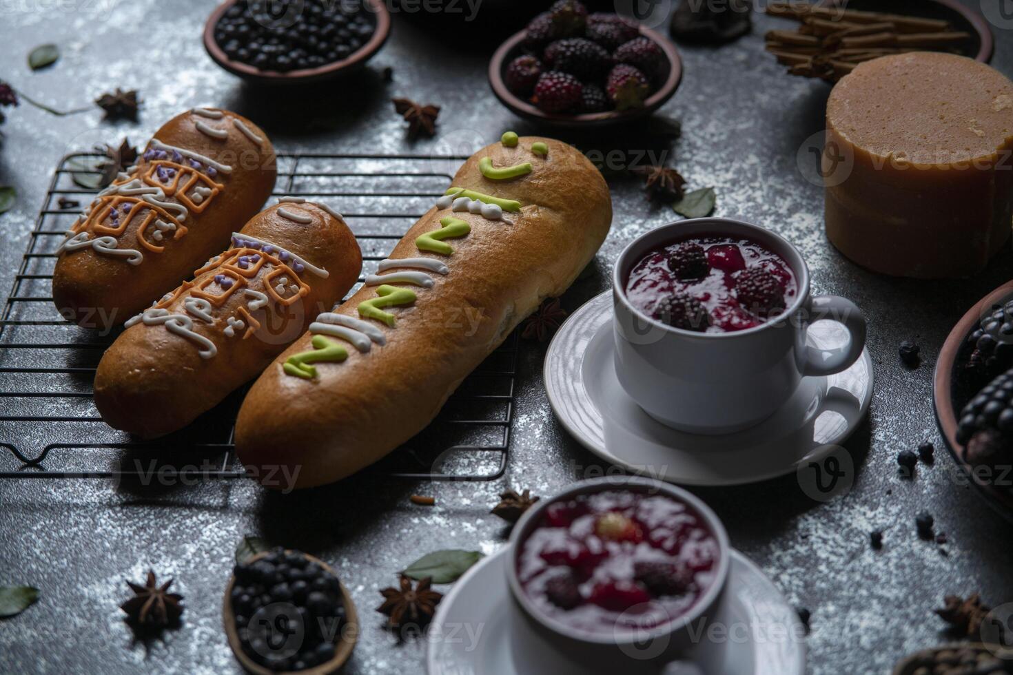 Guaguas de Pan with cups of Colada Morada, traditional Ecuadorian food for the day of the dead, surrounded by the ingredients to cook the colada photo