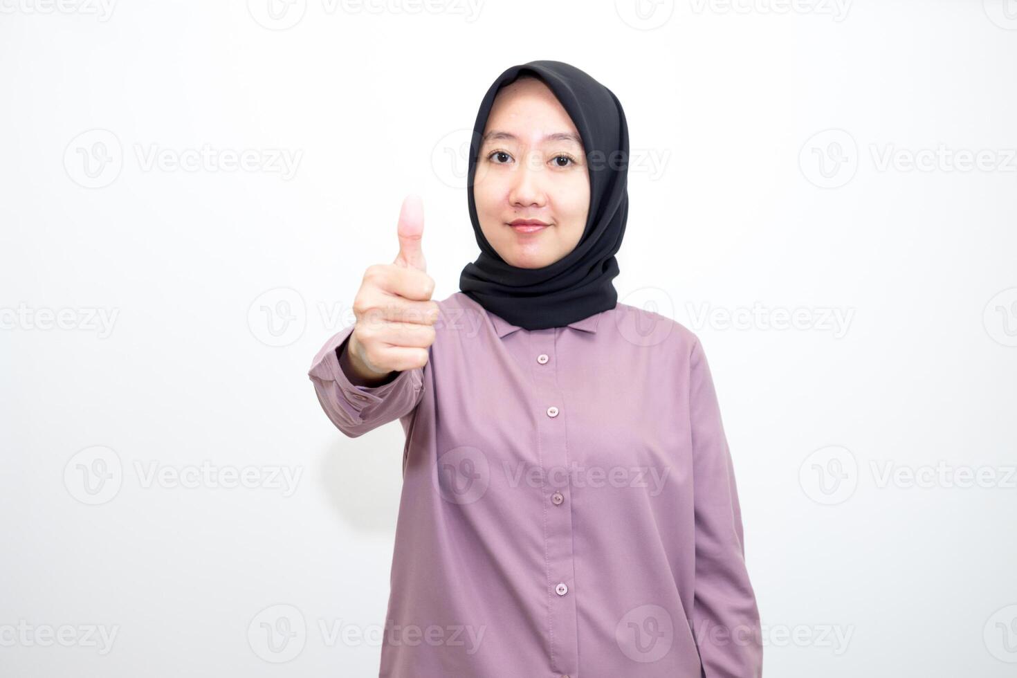 portrait of Indonesian Asian woman wearing shirt and hijab showing ok sign with one hand on eyes looking at camera through fingers. giving sign of agreement. Isolated on white Background photo