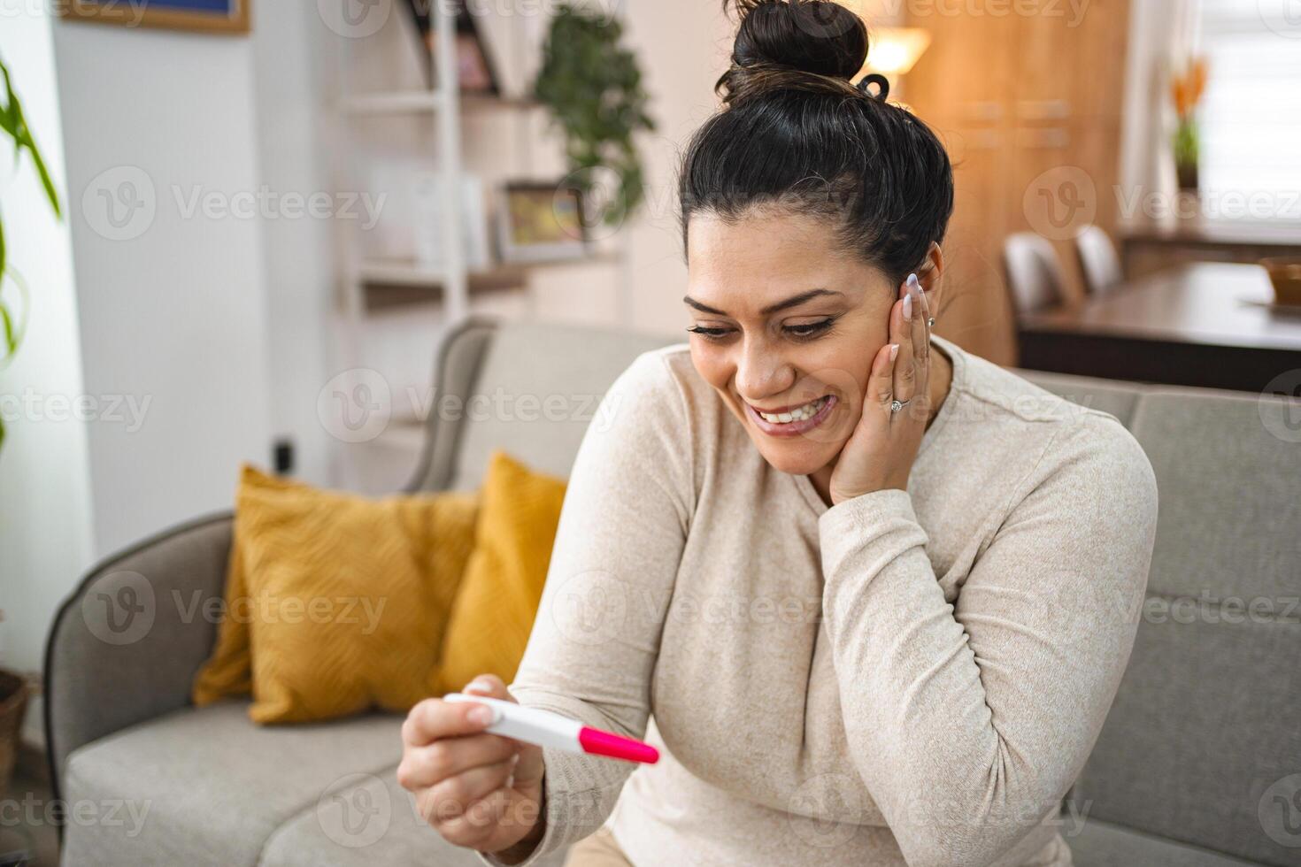 Woman feeling excited after doing a pregnancy test photo