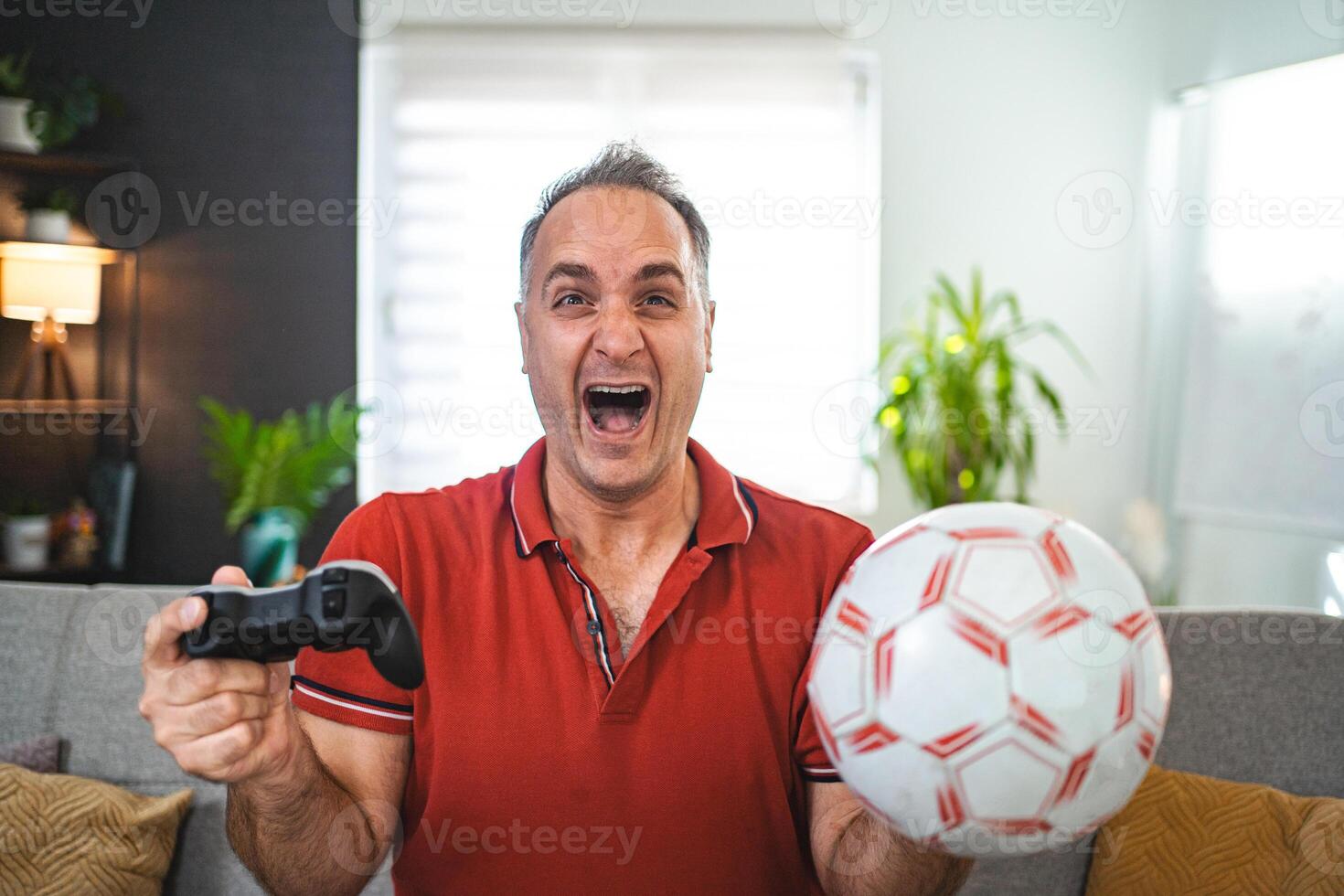Middle age Caucasian man playing soccer game at home photo