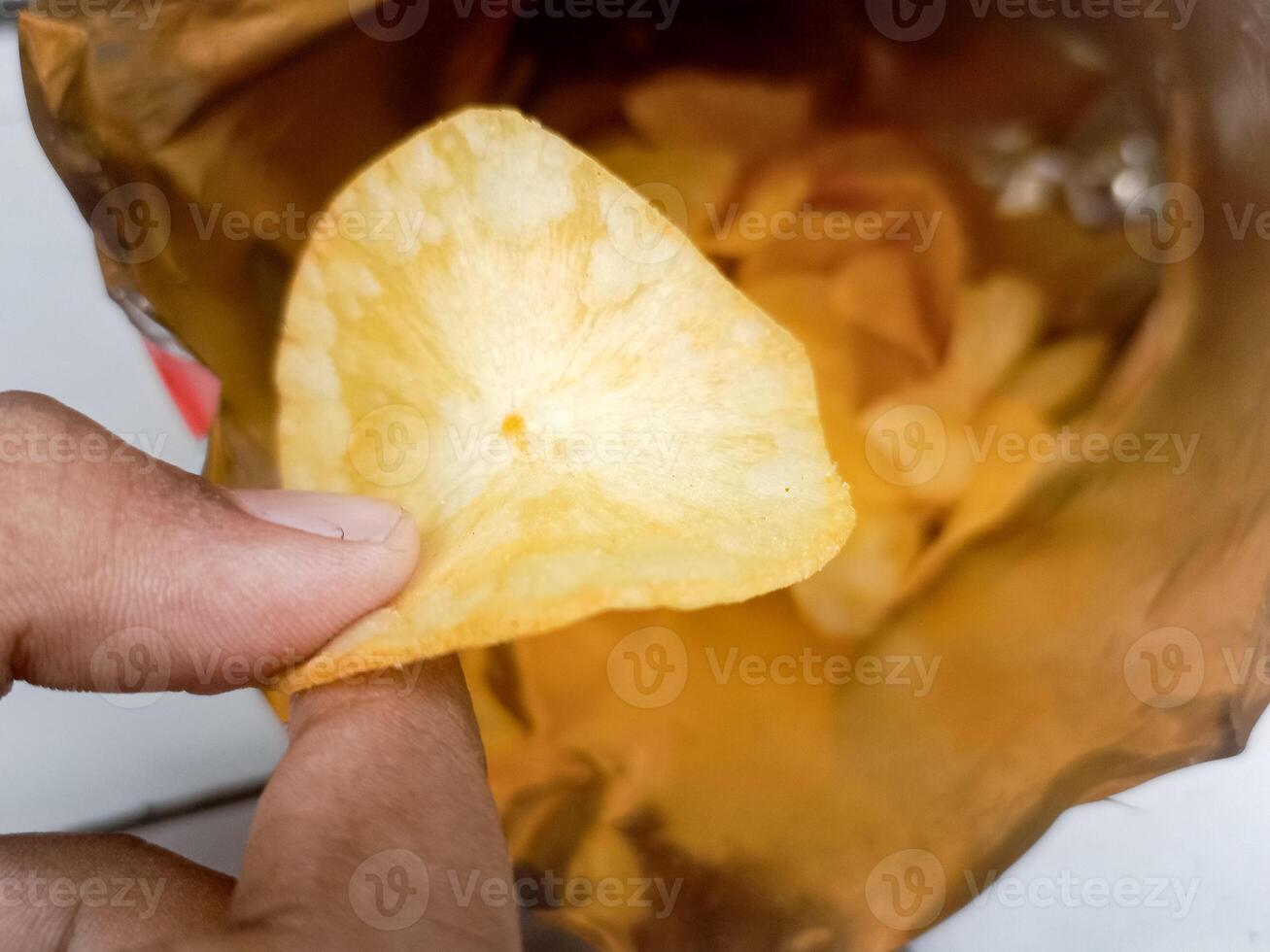 Open package with fresh casava chips. Top view, flat lay photo