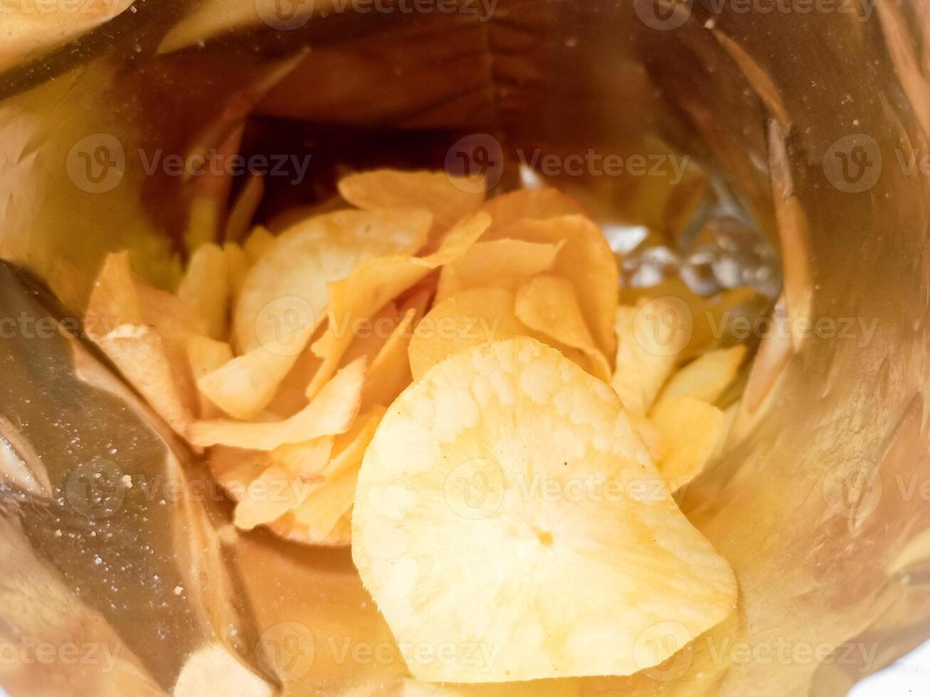 Open package with fresh casava chips. Top view, flat lay photo
