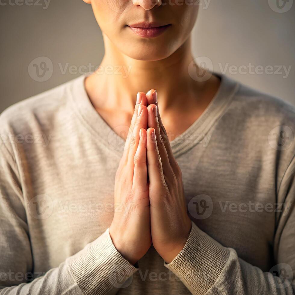 Woman with hands clasped in gesture of prayer or apology photo