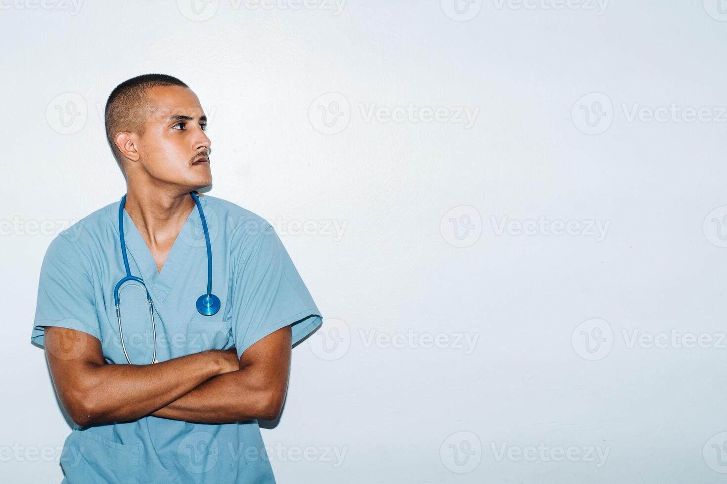 Latin American doctor with folded arms looking in concentration. on a white background. photo