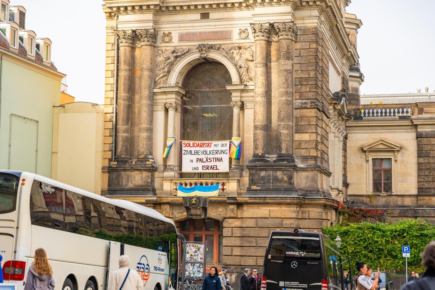 Dresden, Germany - October 19, 2024. The historic building is surrounded by tourists, with bright rainbow flags and a solidarity poster on its facade in Dresden, Germany . photo