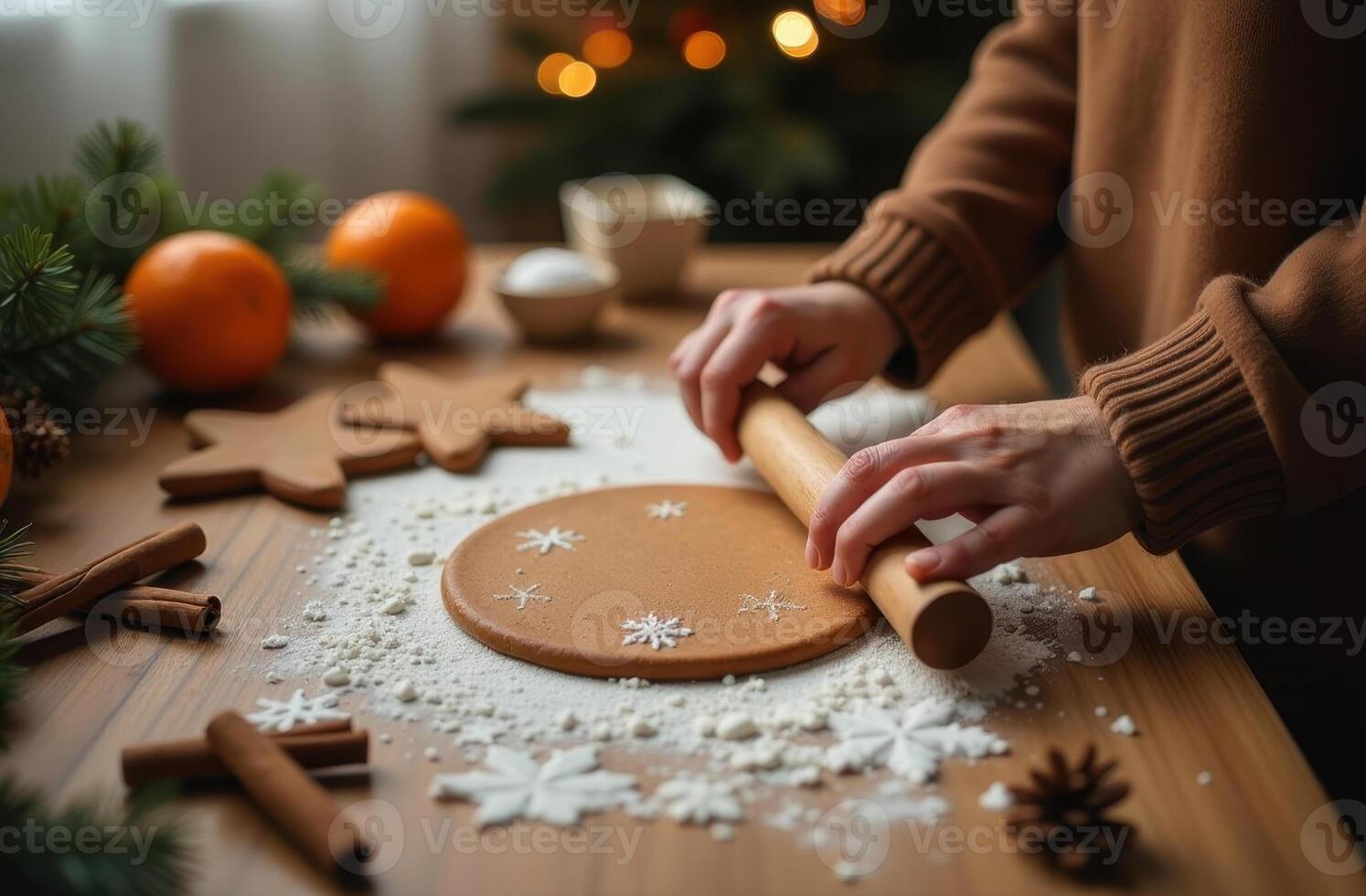 Woman rolling dough with a pin on a floury surface for holiday cookies photo