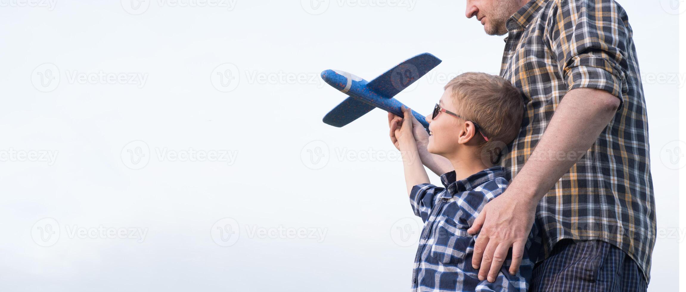 Father and son having fun in the field playing with an airplane photo