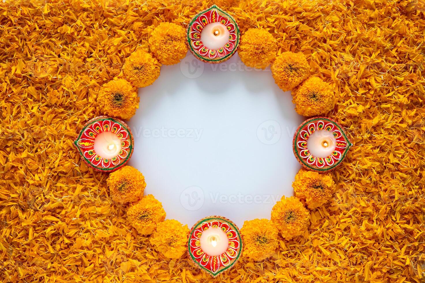 Decorative orange color marigold flowers and petals rangoli with clay diya lamp for Diwali festival on white space background. photo