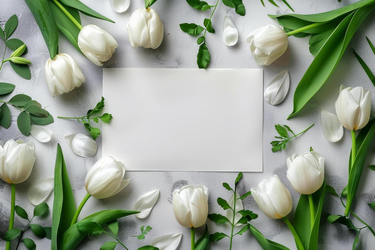 White tulips arranged around a blank card on a wooden table for personal messages and notes photo