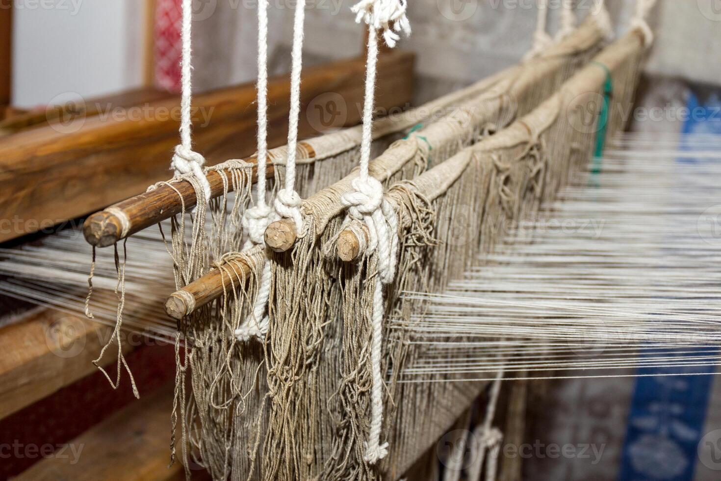 The ancient weaving loom in an interior of a wooden log hut photo