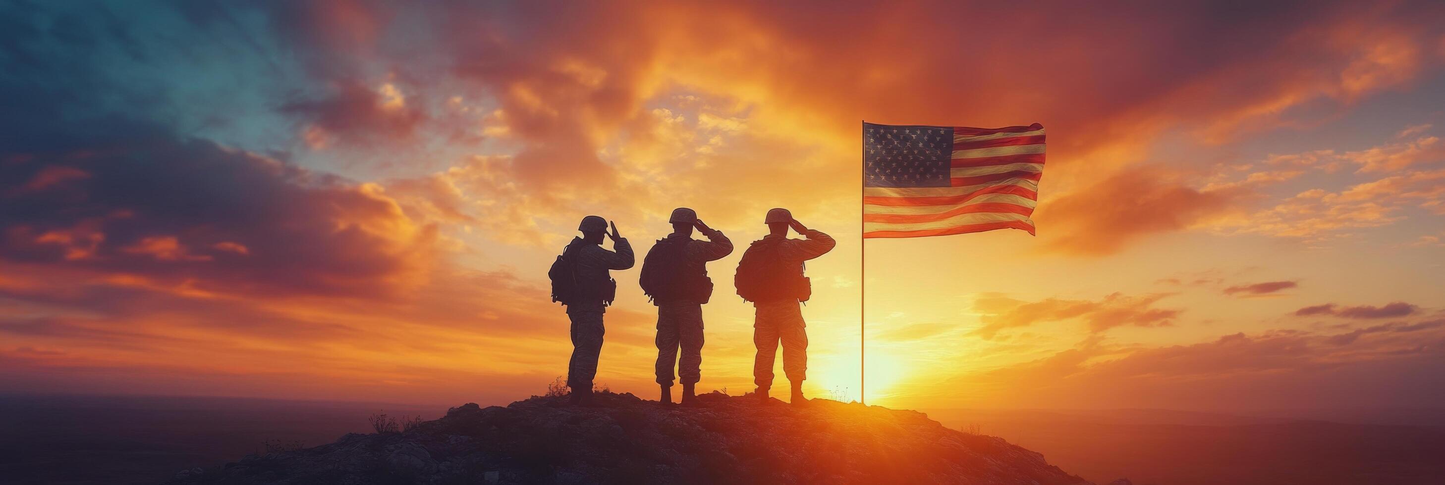 Three soldiers stand on a hillside, saluting while holding an American flag during a stunning sunset photo