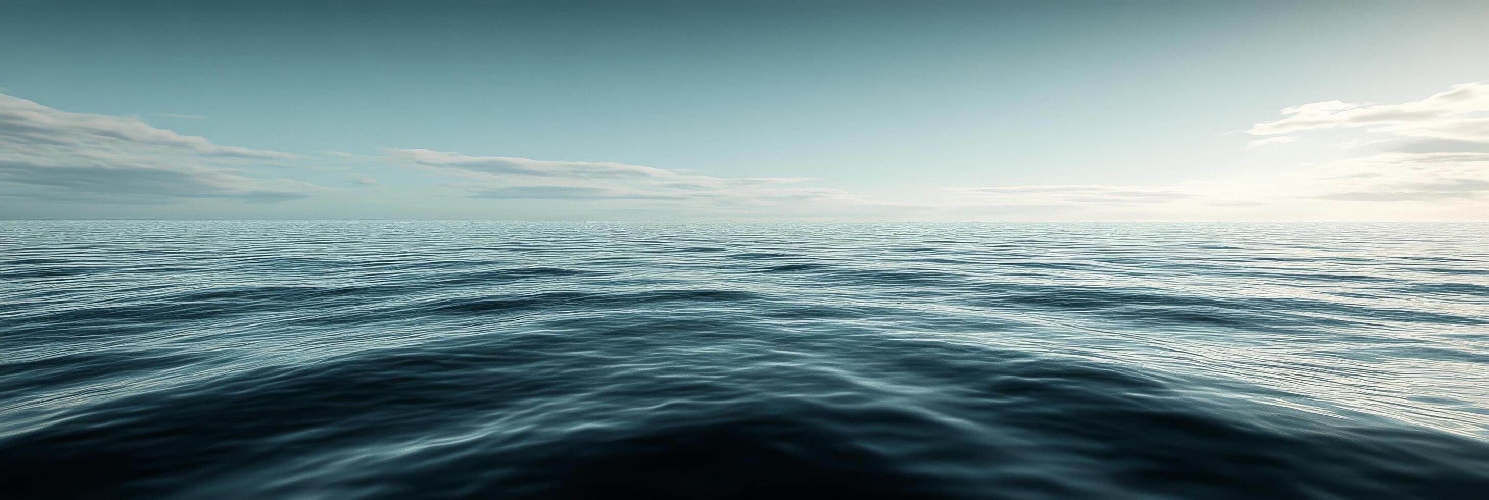 Serene view of calm ocean waters under a bright sky at dawn with subtle waves reflecting sunlight photo
