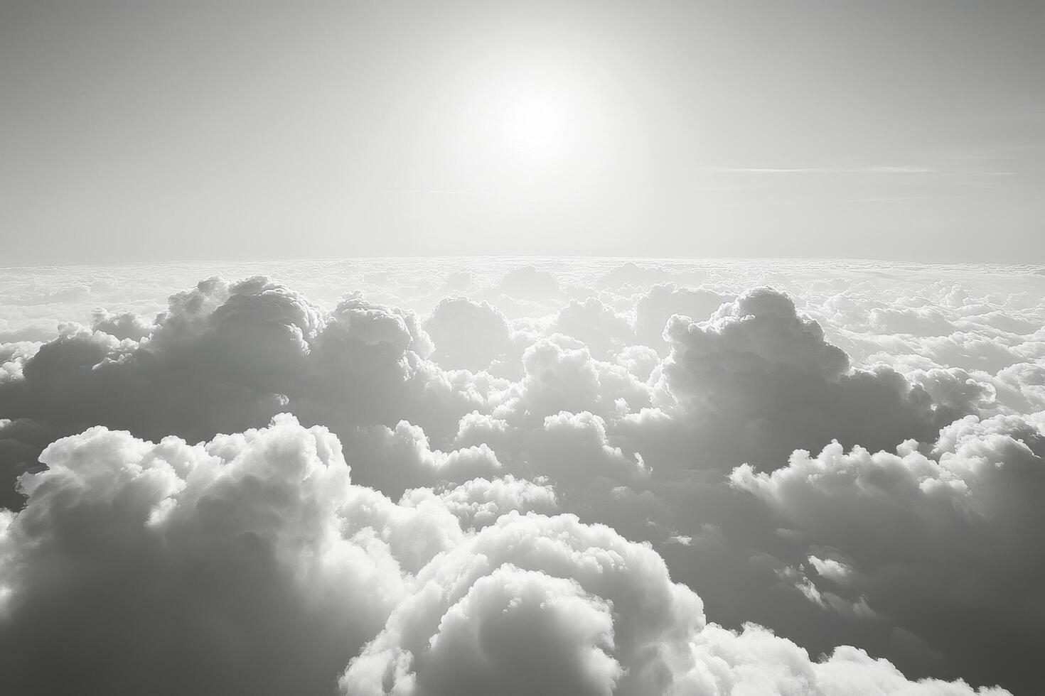Sunrise over a sea of clouds showcasing dramatic light and shadow in black and white photo