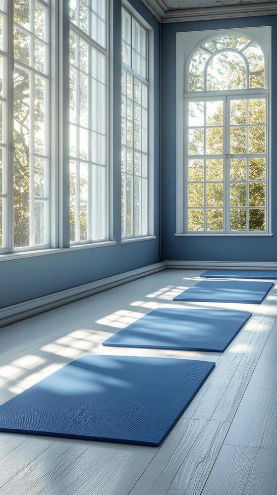 A tranquil yoga studio with blue mats and large windows overlooking autumn trees photo