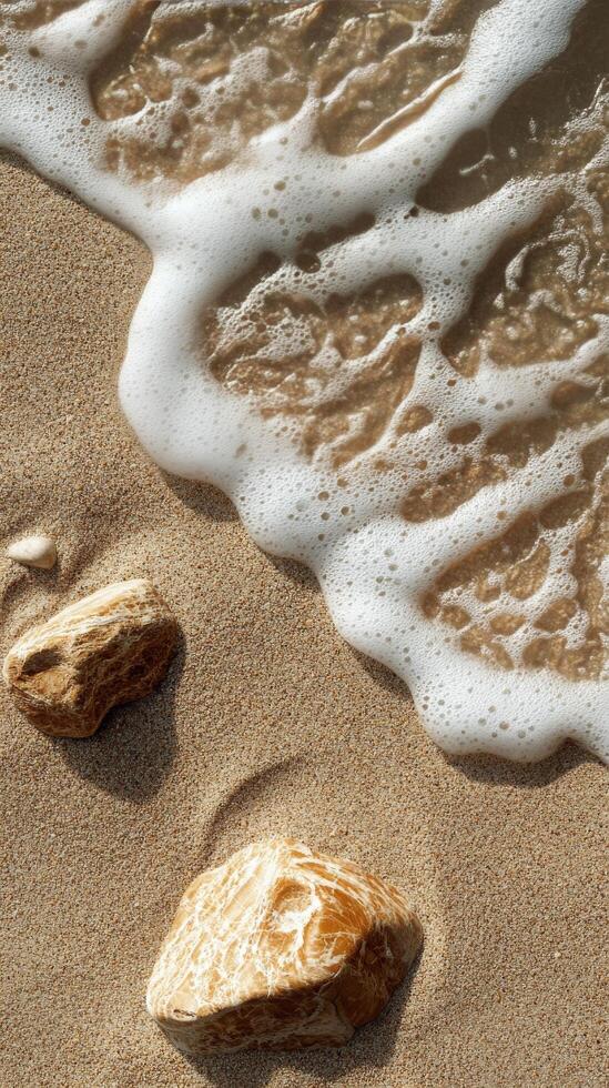 Gentle waves touch sandy shore with smooth stones on a sunny day at the beach photo