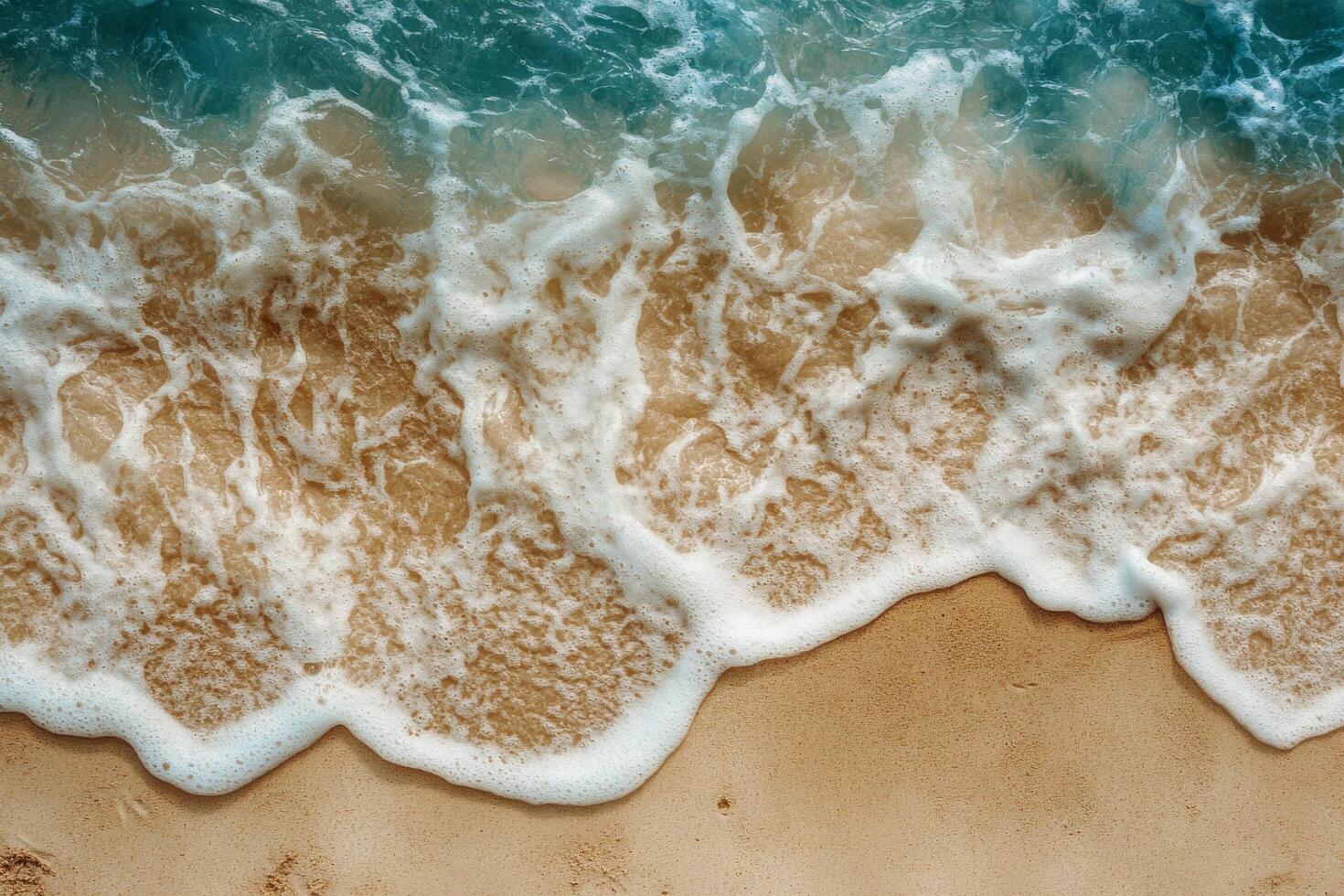 Gentle ocean waves lapping against a sandy beach captured from above during daylight hours photo