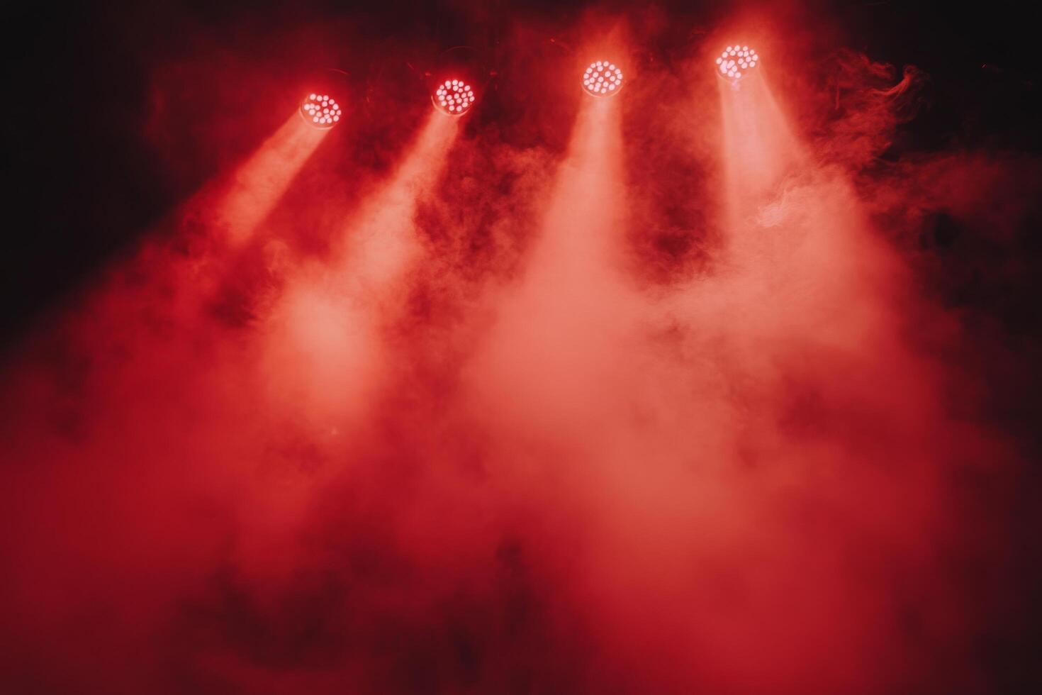 Bright red stage lights illuminate smoky atmosphere in a dramatic performance setting photo