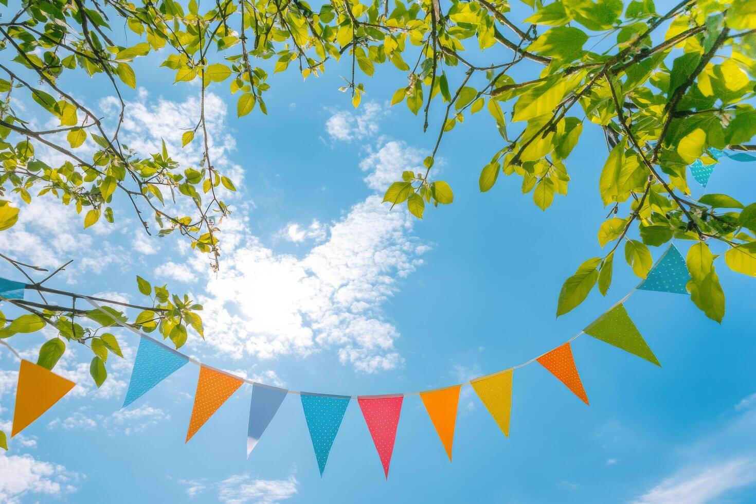 Brightly colored party flags waving under a clear blue sky during a sunny afternoon photo