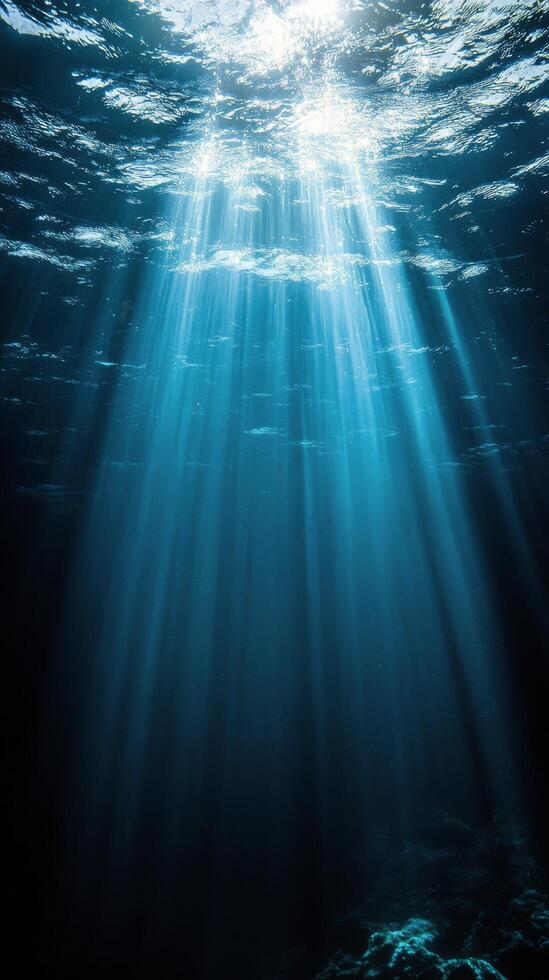 Beautiful underwater landscape showcasing sun rays penetrating clear ocean water at midday photo