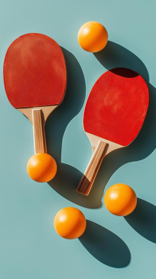 Two red table tennis paddles and a yellow ball on a blue background in a minimalistic arrangement photo