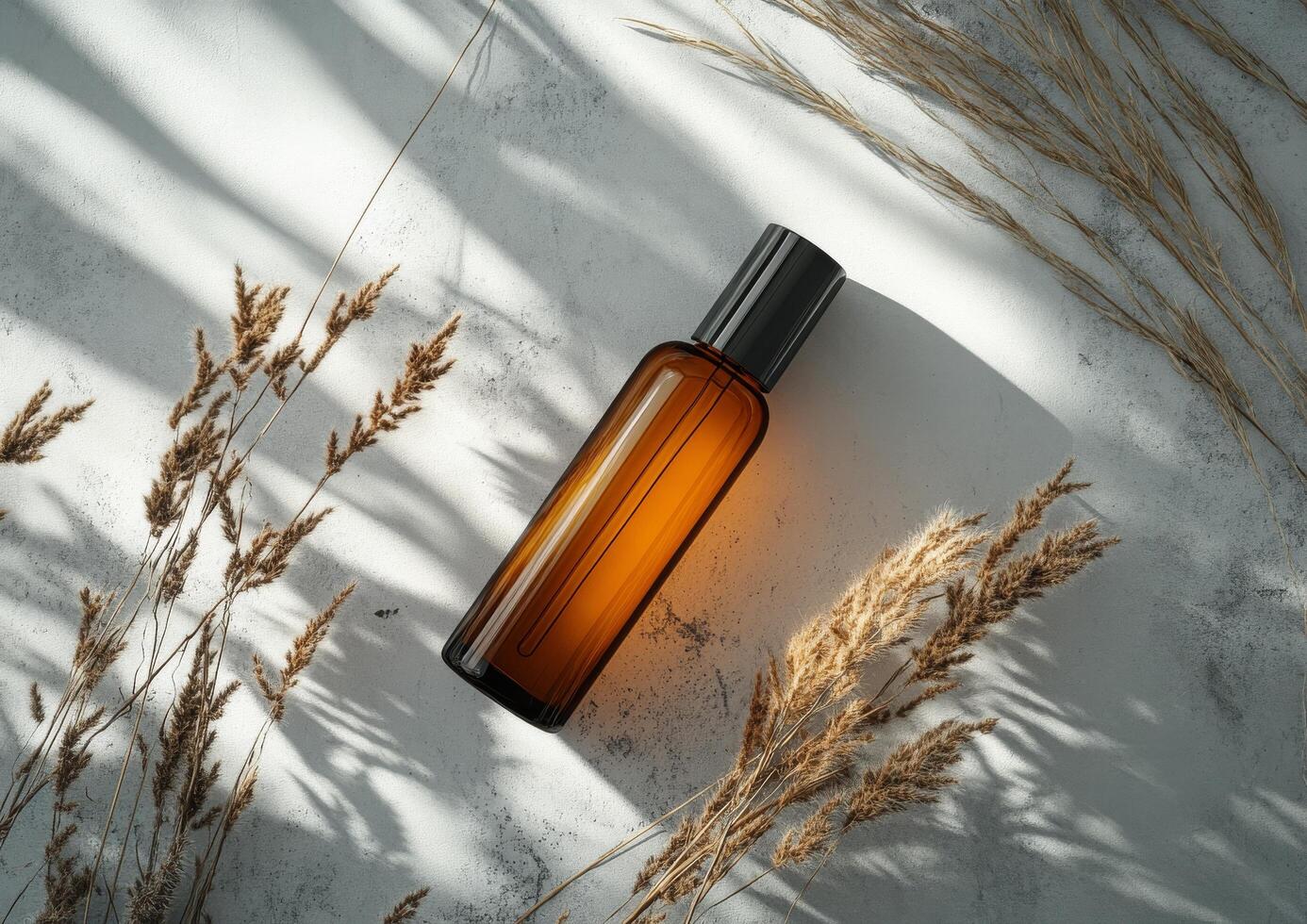 Glass bottle resting on a textured surface surrounded by dried plants in natural lighting photo