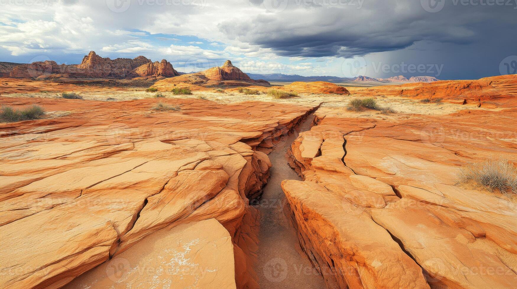 A Crack in the Desert Landscape with Sandstone Formations and Dramatic Clouds photo