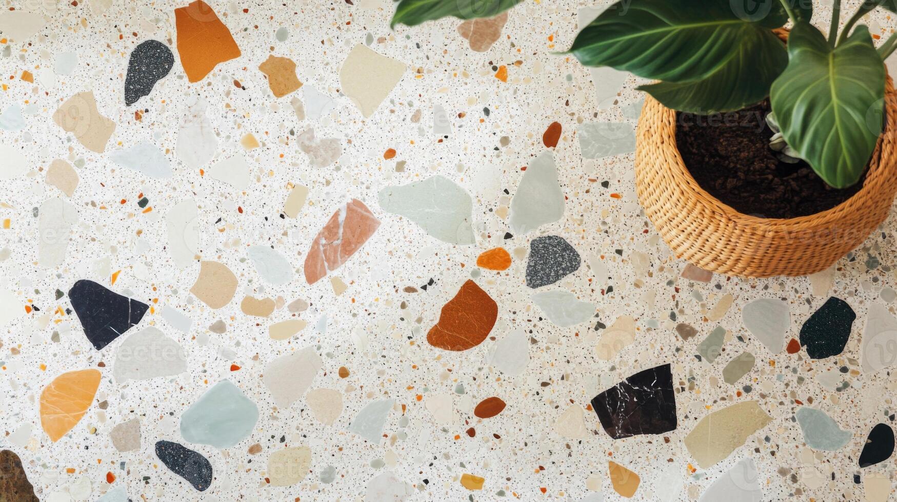 A plant in a wicker pot on a terrazzo floor photo
