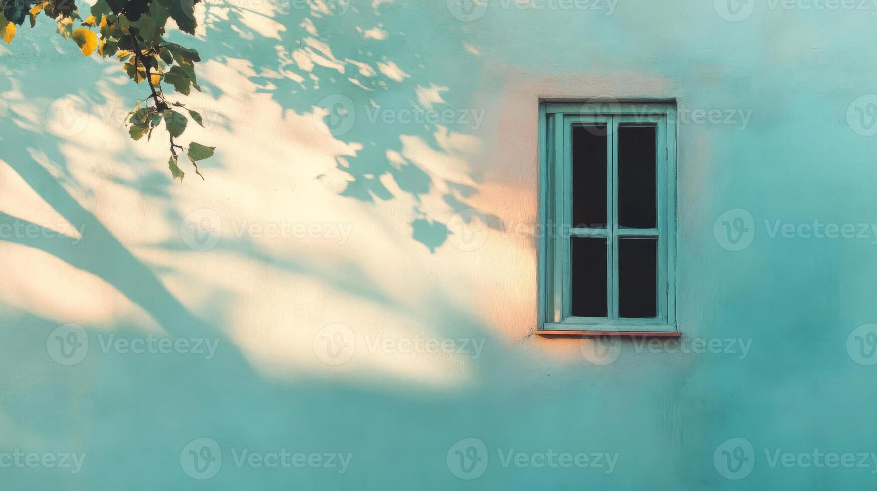 A Single Window with Leaf Shadows on a Light Blue Wall photo