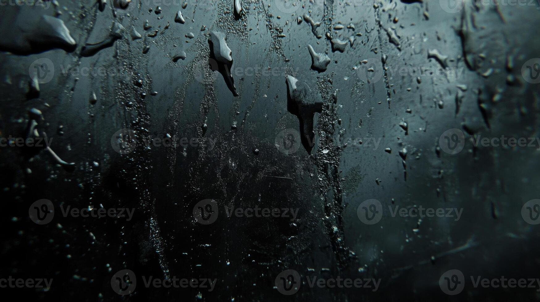 Close-up of raindrops on a dark glass surface photo
