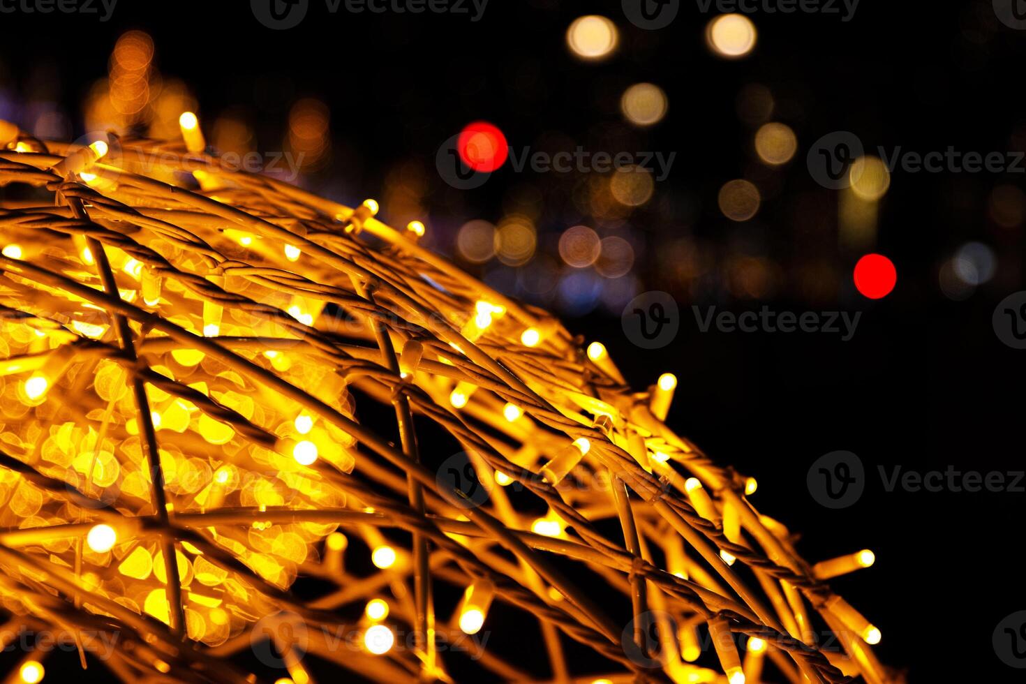 Closeup of intertwined golden string lights. Abstract view of crisscrossing glowing yellow LED garland with small bright bulbs, radiating light against a dark background. Berlin, Germany. Copy space photo