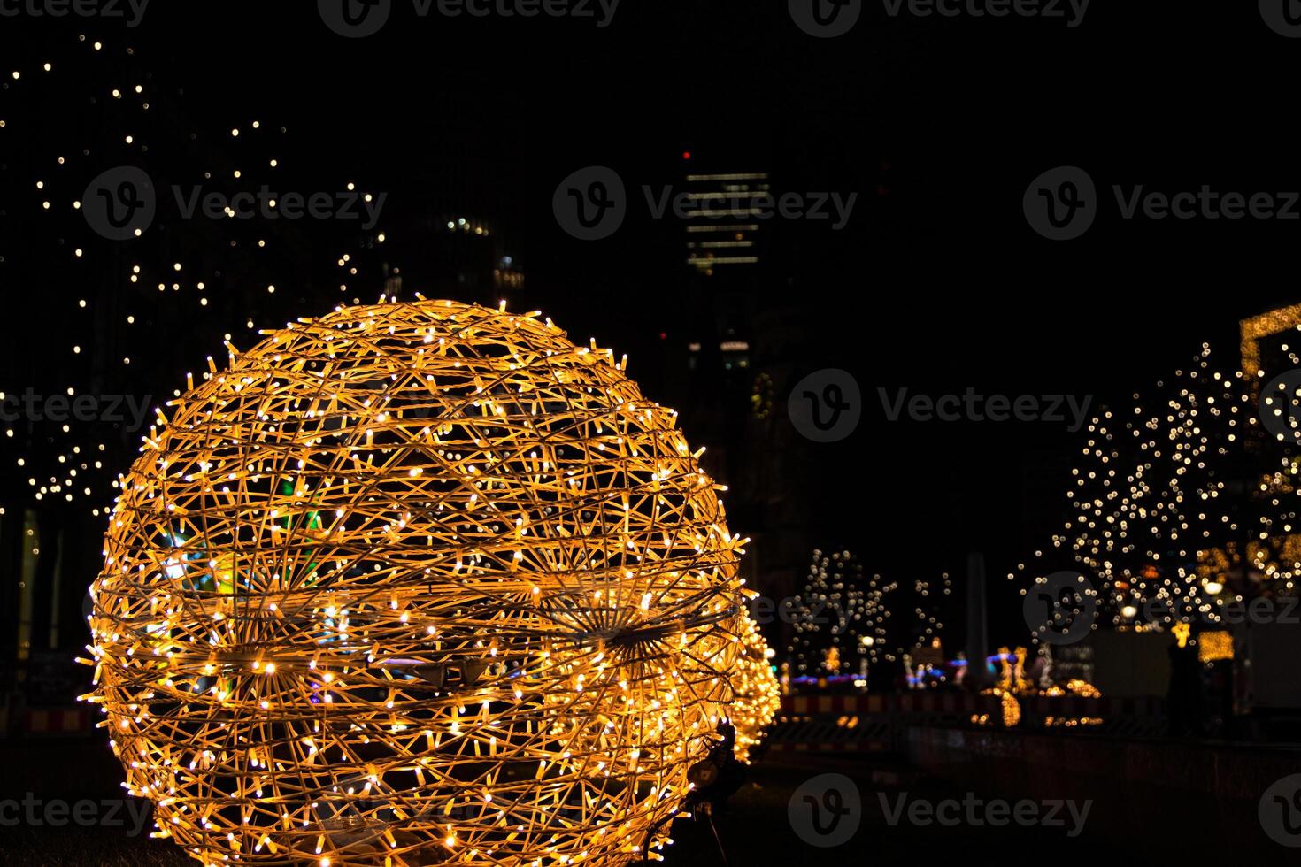 Closeup of intertwined golden string lights. Abstract view of crisscrossing glowing yellow LED garland with small bright bulbs, radiating light against a dark background. Berlin, Germany. Copy space photo