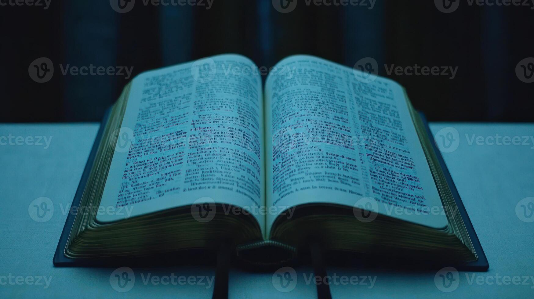 Soft light illuminates a book's pages, showcasing intricate text and details photo