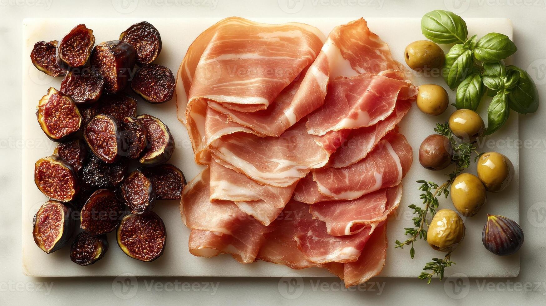 A delightful spread features sliced prosciutto, dried figs, olives, and vibrant basil photo