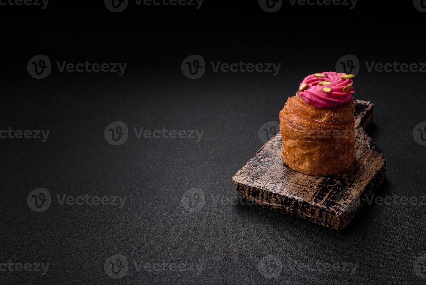Sweet craffin or panettone garnished with raspberry and pistachio flavored cream photo