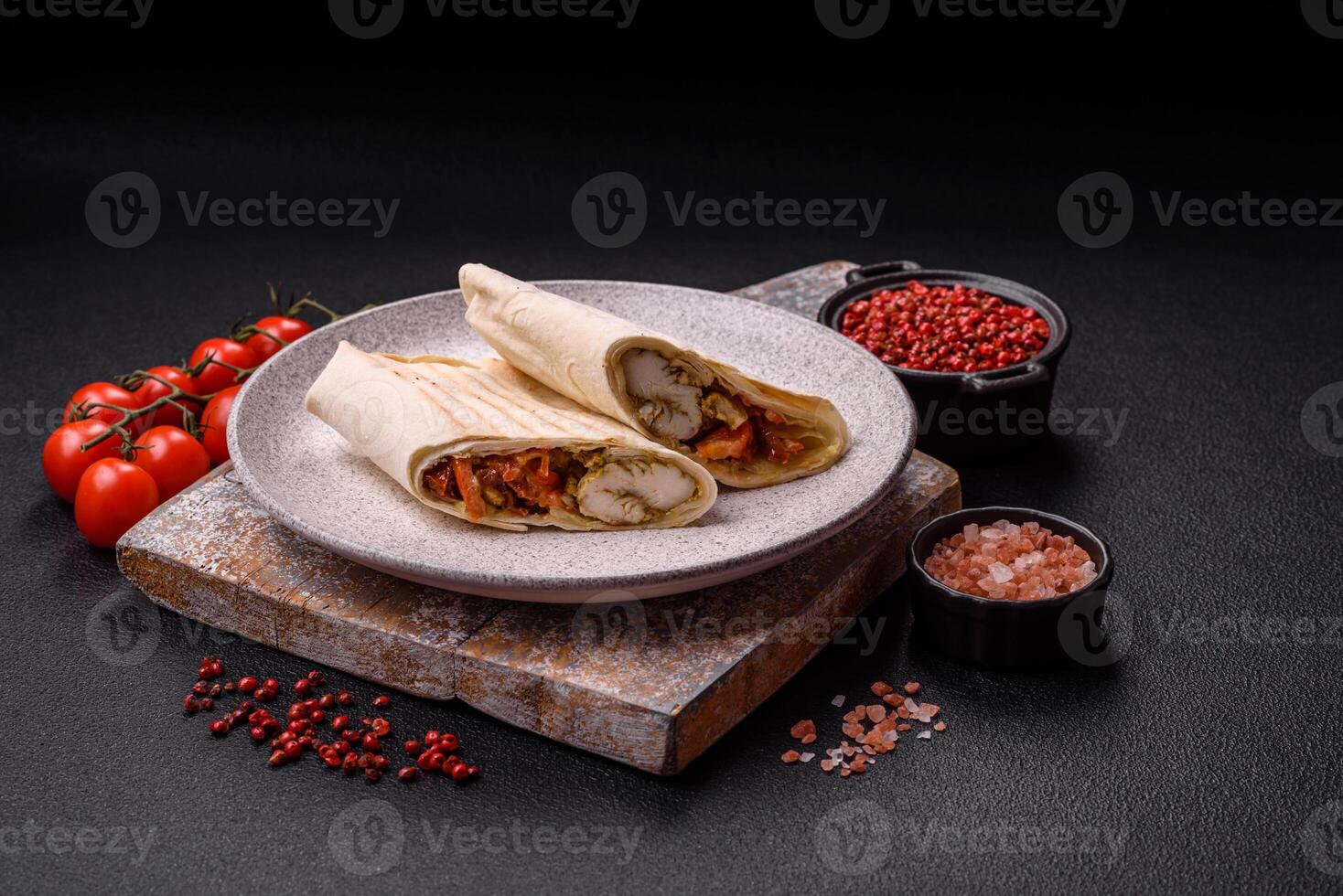Roll with pita, meat, tomatoes, cheese, sauce, salt and spices photo