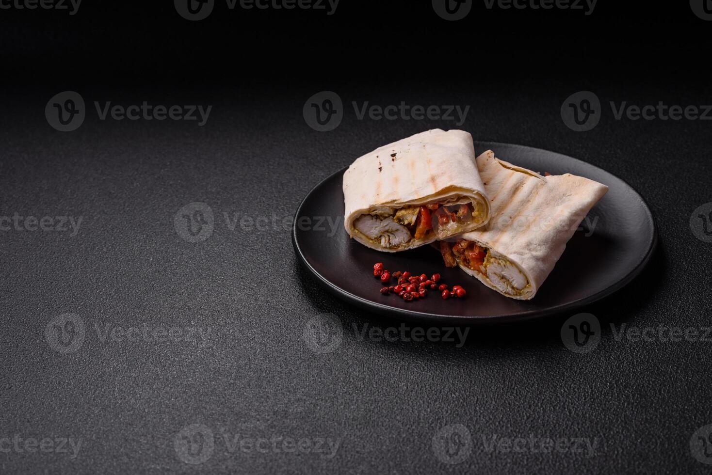 Roll with pita, meat, tomatoes, cheese, sauce, salt and spices photo