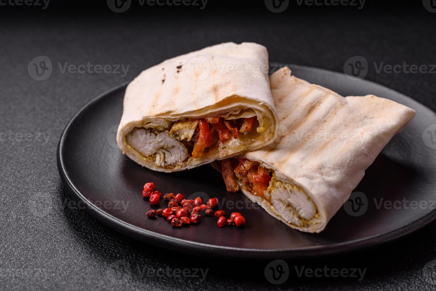 Roll with pita, meat, tomatoes, cheese, sauce, salt and spices photo