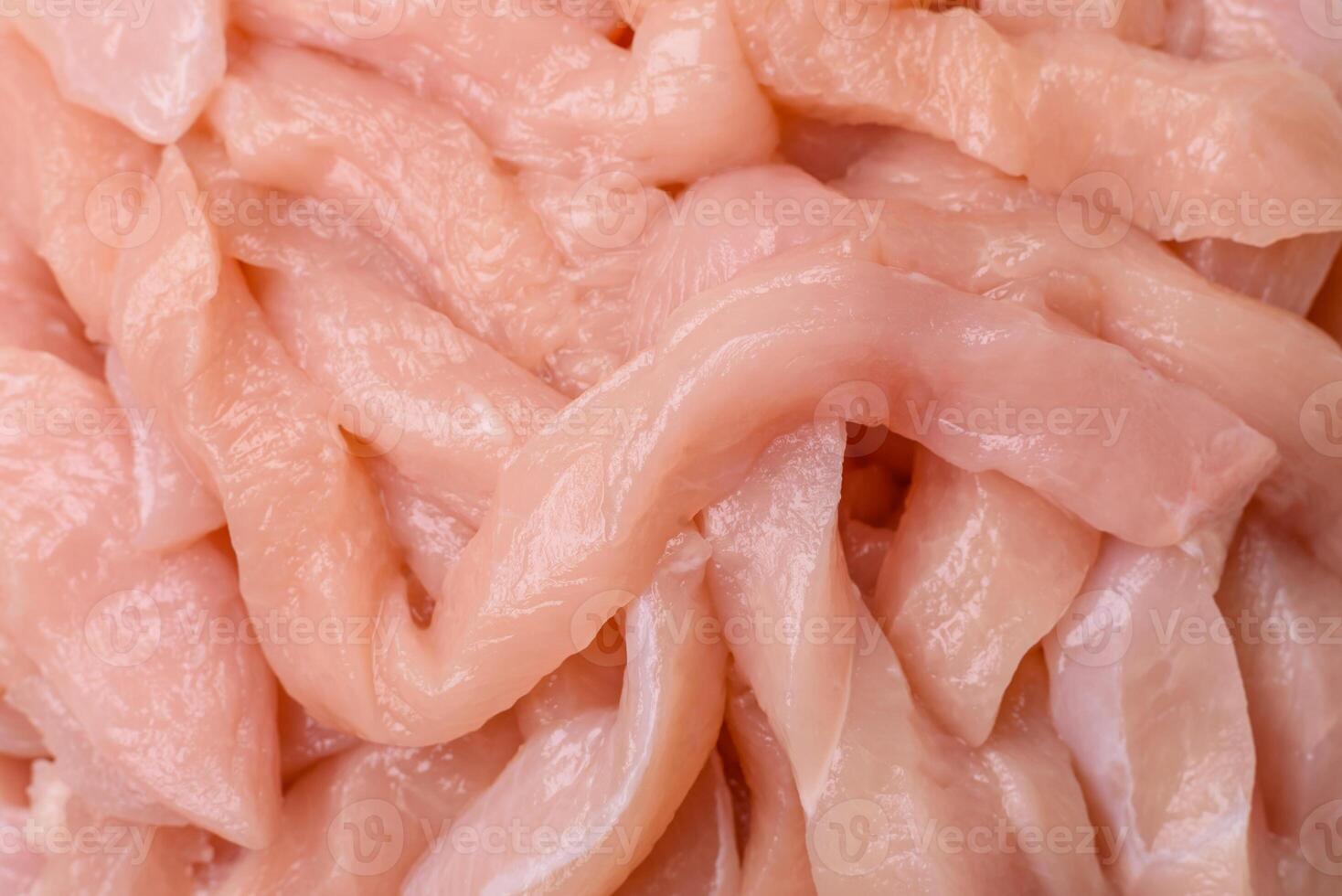 Raw chicken fillet cut into strips with spices and herbs photo