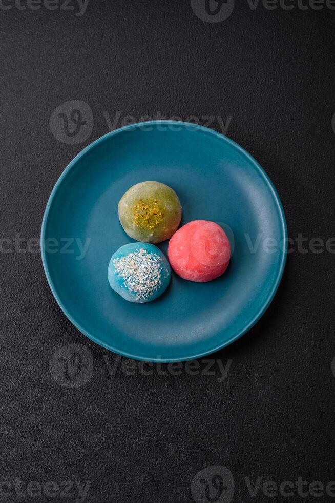 Delicious colorful asian mochi sweets with rice dough shell and fruit filling photo