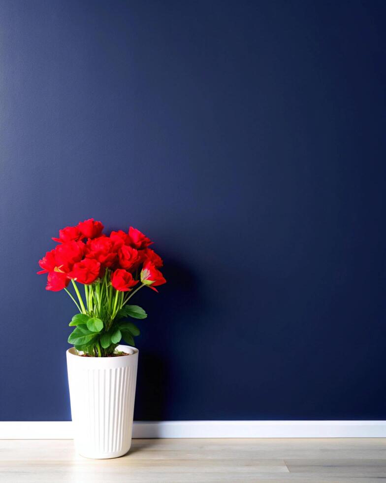 A vase of red flowers sits on a table in front of a blue wall photo
