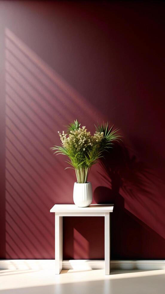 A white table with a plant in front of a red wall photo